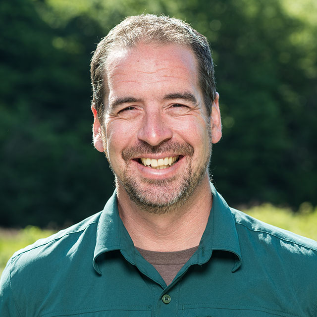 A headshot photo of Corey Clarke in a Parks Canada uniform.